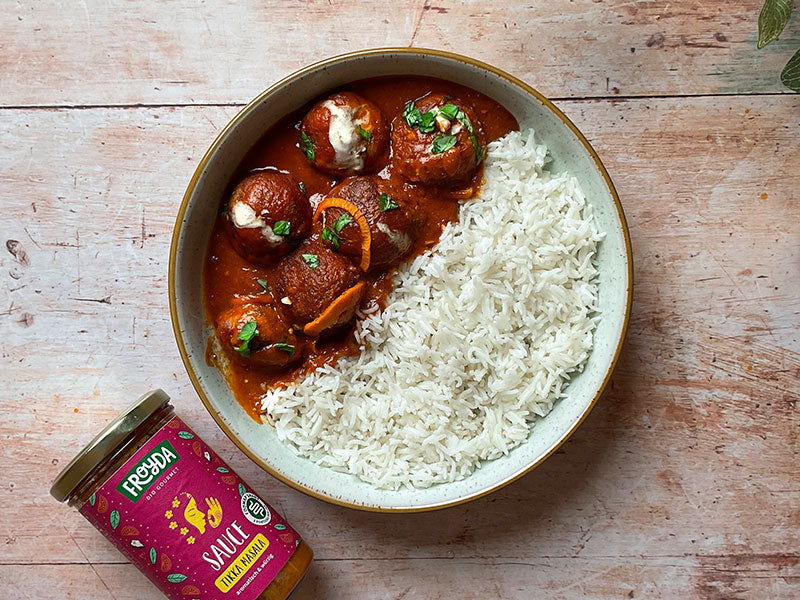 Plate with kofta tikka masala and rice next to Froyda Tikka Masala jar