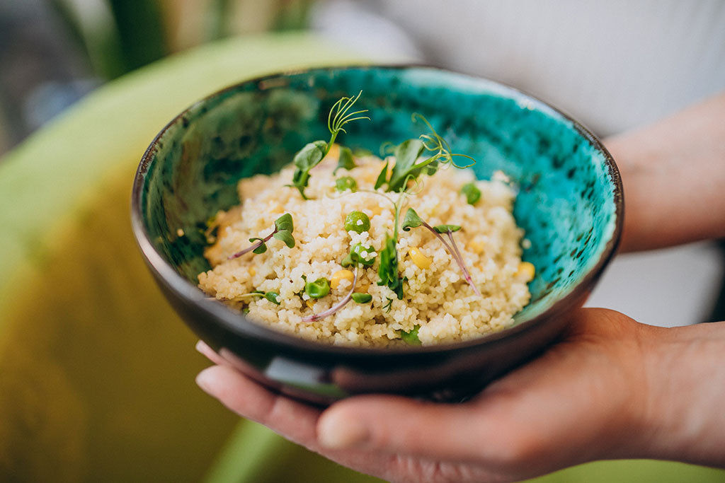 Hands holding a bowl of millet